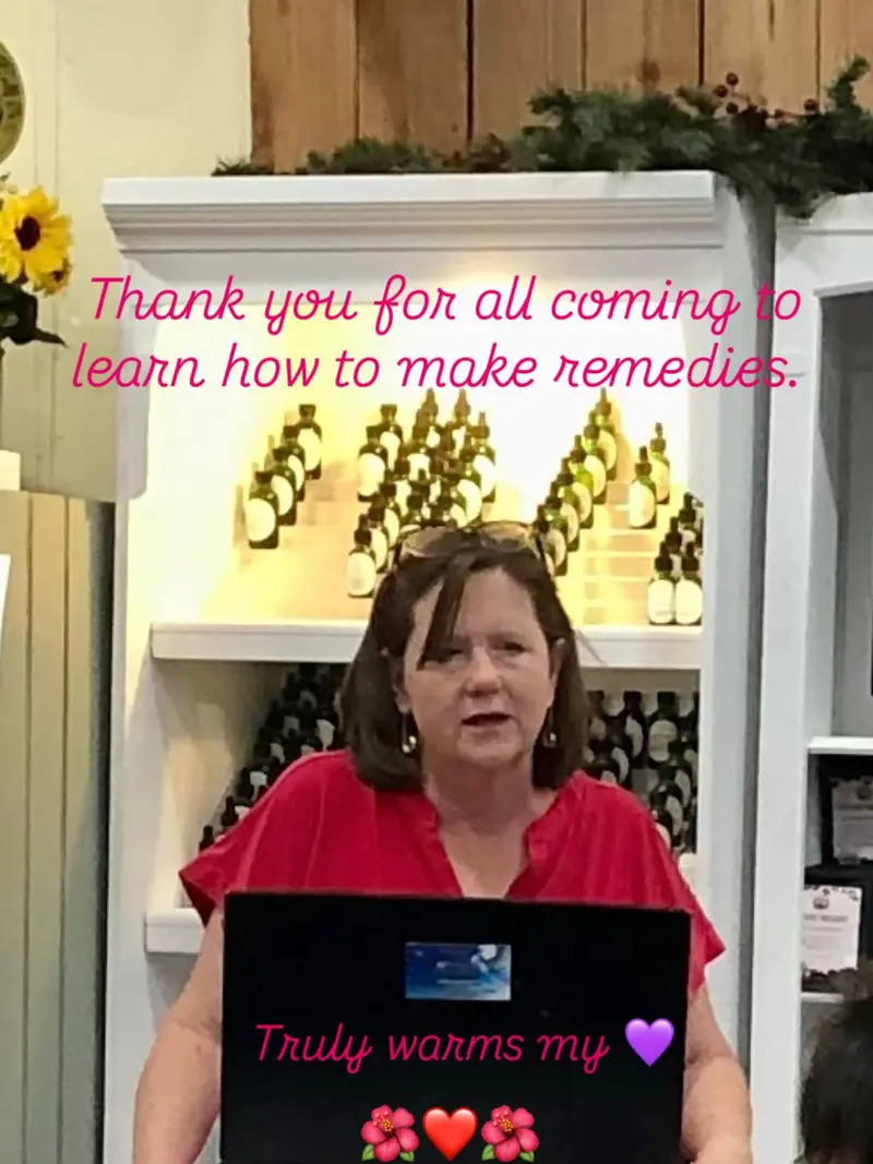Toni behind her laptop at a remedy-making class, with a thank-you note to her students written across the photo.