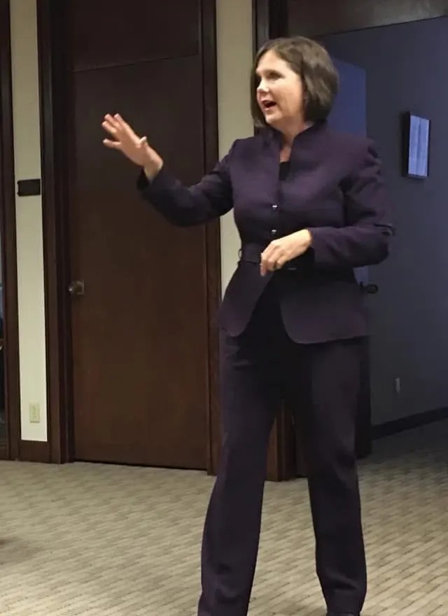 Toni on her feet mid-presentation, taking a question from the room.